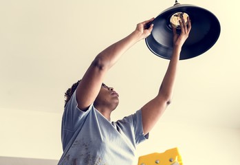 Wall Mural - Woman changing lightbulb