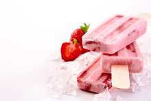 Three frozen popsicles with strawberry ingredients