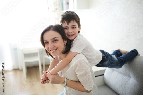 Beautiful Brunette Mom And Son Hugging On Couch Beautiful Brunette Mom And Son Hugging On Couch