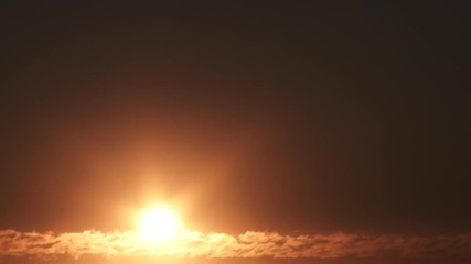 Wall Mural - From the black of night, bright and warm sun rises above cloud horizon, night to day time lapse.