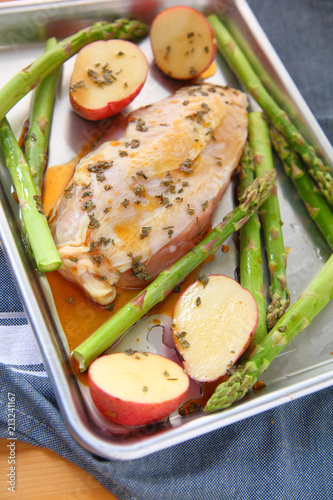 Fotografía Preparing dinner for one person with chicken breast, potatoes and asparagus