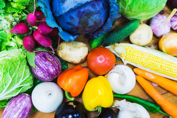 Fresh vegetables on the wooden counter of a small vegetable market.