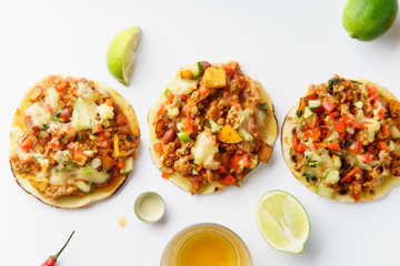 Mexican tacos with chili con carne, grilled sweet potatoes and grated cheese on white background. Text space