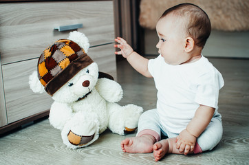 baby on the floor playing with a soft toy