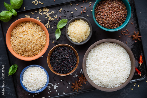 Fotomural Variety of rice - red rice, black rice, basmati, whole grain rice, long grain parboiled rice and arborio rice - in bowls
