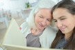 © auremar - woman and her granddaughter looking at an album