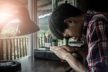 Young man  praying on bible.