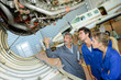 © auremar - airplane engineer showing apprentices mechanics inside undercarriage