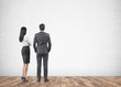 © ImageFlow - Business partners looking at wall, rear view