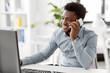 © Syda Productions - business, people, communication and technology concept - smiling african american businessman with computer calling on smartphone at office