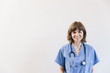 © Cavan Images - Portrait of female doctor with stethoscope standing against white background