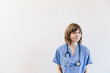 © Cavan Images - Portrait of female doctor with stethoscope standing against white background