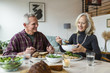 © Cavan Images - Smiling couple having lunch at dining table