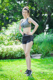 Asian Sport young woman slim fitness in sports bra smiling and standing  hands on hips in park exercise workout and running in sport wear. Healthy  lifestyle and fashion concepts. Stock Photo