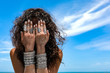 © zolotareva_elina - beautiful young woman on the beach background cover her face with hands with silver bracelets and rings