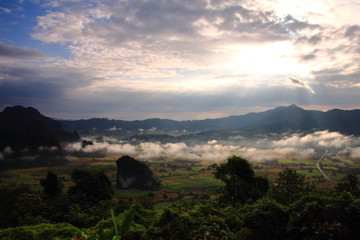 Rock mountain protruding from rice field. Morning fog on sunrise in the Phulanka, Phayao Thailand.