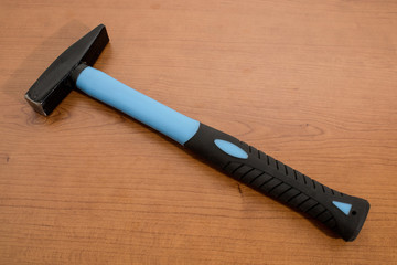 Tools, blue and black hammer on a wood table