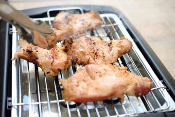 Delicious pieces of meat with spices on the electric grill.