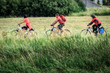 © Frozen Action - Drei Radfahrer machen einen Ausflug mit dem Fahrrad über eine Wiese