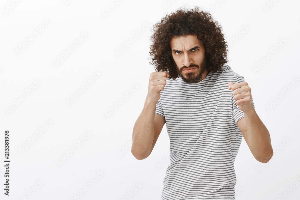Outraged Photo Examples Indoor shot of outraged bully with beard and afro haircut, standing in ...