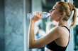 © whyframeshot - attractive caucasian woman relax with pure water after workout with happiness and joyful in gym healthy ideas concept