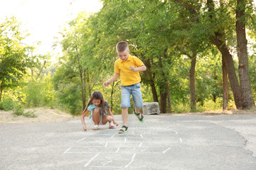 Wall Mural - Cute little children playing hopscotch, outdoors