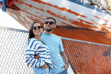 Wall Mural - Young hipster couple in stylish jeans on pier