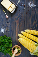 Wall Mural - Raw sugar corn, sea salt, spices, herbs, butter on a dark wooden table. Top view.