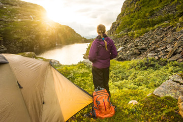 tourist tent and woman in mountains sunset norway