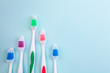 Toothbrushes on light blue background, close up different kinds of Toothbrushes, new not used, isolated for text insertion, one of the best, old and new brushes