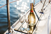 Romantic Luxury Evening On Cruise Yacht With Champagne Setting. Empty Glasses And Bottle With Champagne And Tropical Sunset With Sea Background, Nobody.