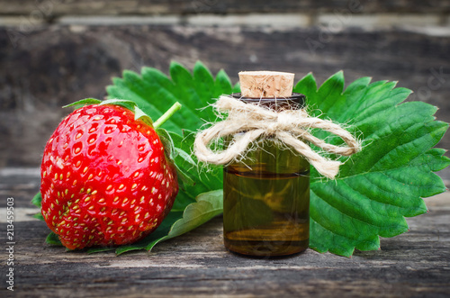 Fotografie, Obraz Strawberry concentrate juice in the small brown bottle