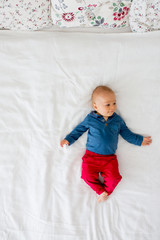 Canvas Print - Mother and toddler baby boy, lying in bed, hugging with love, high angle shot, from above