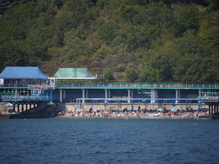 The beach with a huge number of tourists on sun loungers, under umbrellas and under a special cover