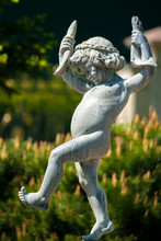 A Statue Of A Naked Little Boy With Two Fish In His Hands