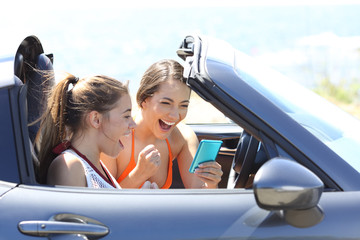 Excited tourists in a car reading online news