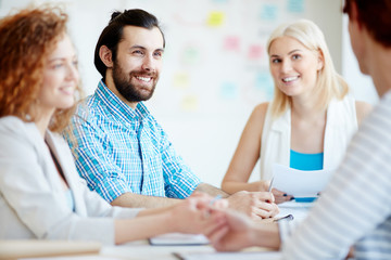 Wall Mural - Group of young businesspeople having discussion of creative ideas at working meeting