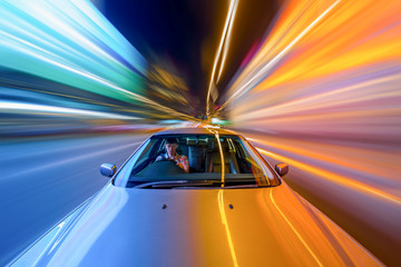 Blurred urban look from fast driving car to back side and driver at winter night. Longexposure shot.