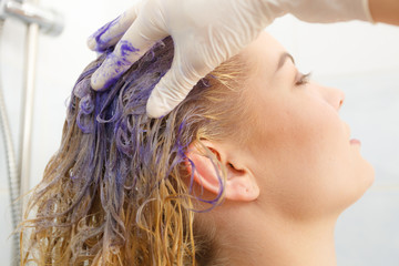 Woman applying toner shampoo on her hair