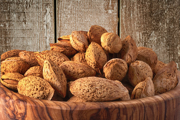 Wall Mural - Almonds in wooden bowl on wooden background