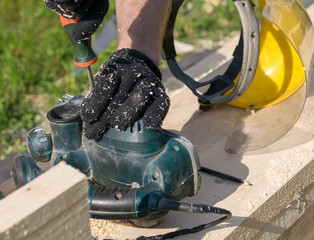 carpenter repairs woodworking tools on the street on lumber