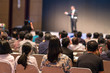 © THANANIT - Rear side of Audiences sitting and listening the speackers on the stage in low light conference hall, event and seminar concept
