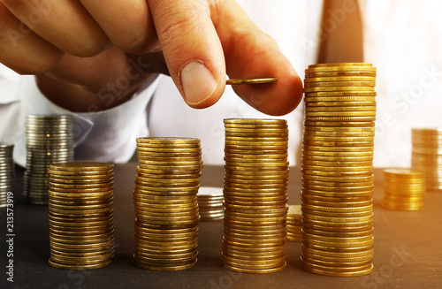 Fotografía Profit growth. Man is putting coin on a stack. Wealth management.