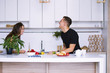 © mikitiger - cute young woman and man in white kitchen near table in house