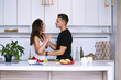 © mikitiger - cute young woman and man in white kitchen near table in house