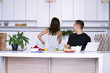 © mikitiger - cute young woman and man in white kitchen near table in house