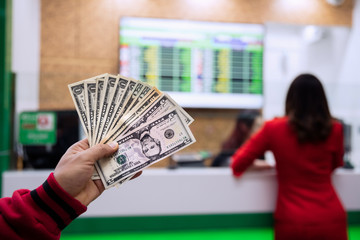 Young asian hand with money in cash department window at international airport,currency exchange concept.