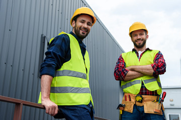 two architects in safety vests and hardhats standing on construction