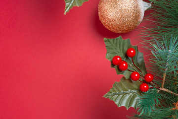 Poster - Christmas decoration and fir branches wreath with cherry and pine cone on red table background. winter holiday festive celebration concept.copy space for greeting card.