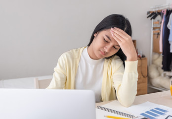 Poster - Asian female freelancer headache and stress while working with laptop on table in bedroom at home.Work at home concept.work from home concept.